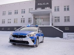 Nowy radiowóz na tle Komendy Powiatowej Policji w Brzesku